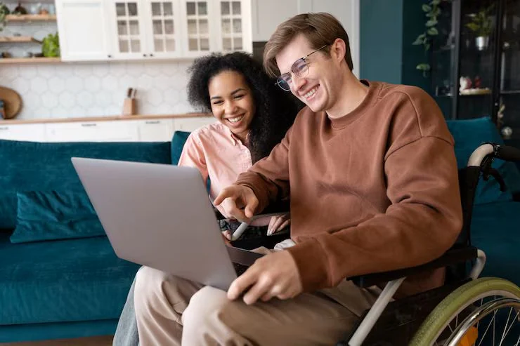 NDIS support worker helping participant with laptop